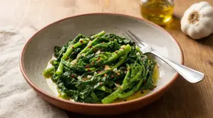 Cime di rapa cotte servite in un piatto fondo con olio, aglio e peperoncino